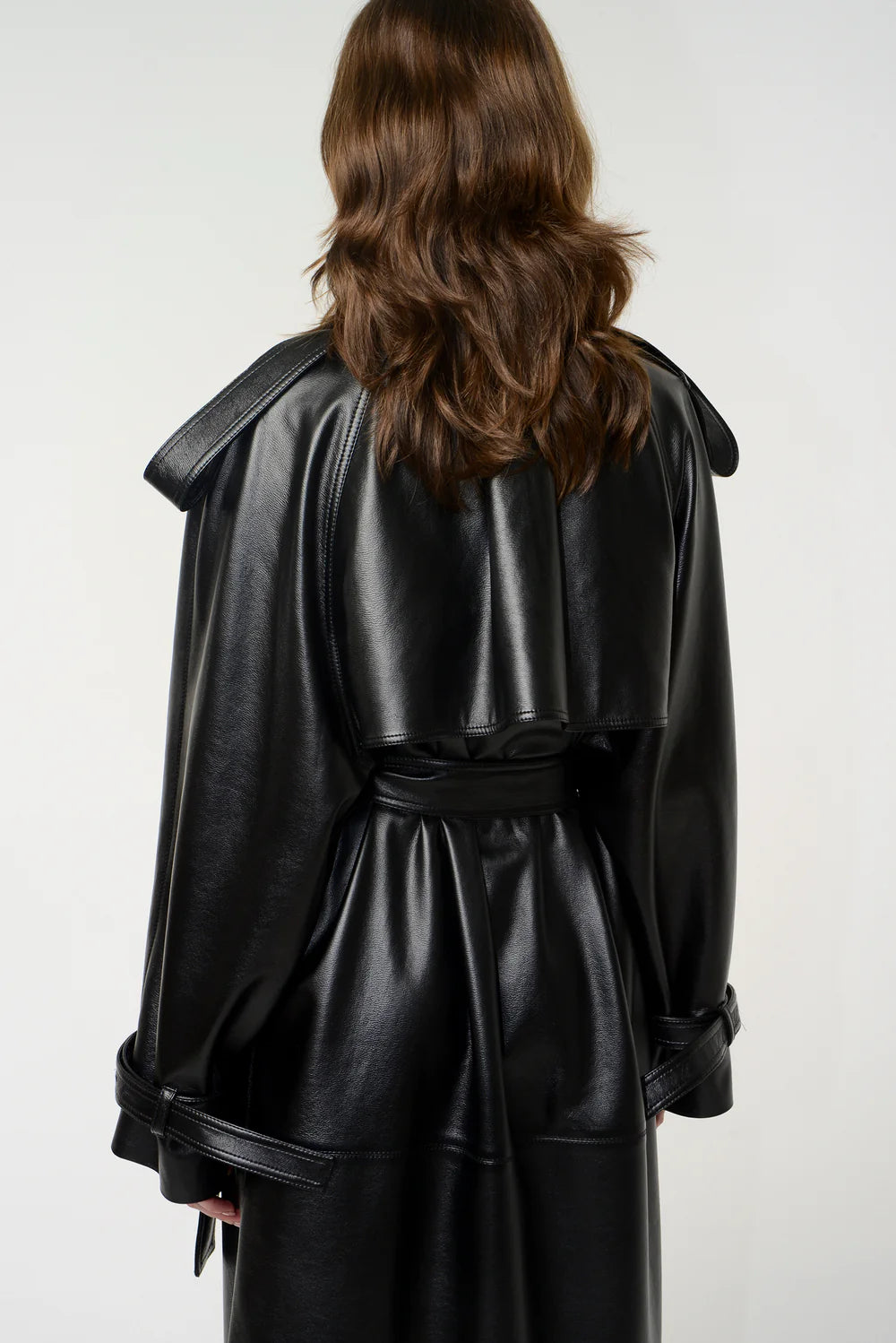 Black leather long trench coat with double-breasted design, lapel collar, shoulder and wrist straps, and detachable waist belt – Movenera.