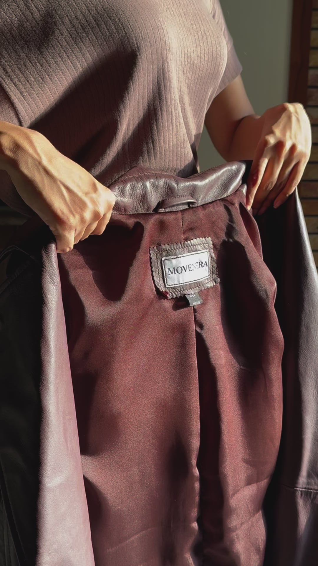 A close-up video of the Burgundy Genuine Leather Trench Coat, focusing on the lapel collar, wrist straps, shoulder details, and side pockets. The video demonstrates the high-quality craftsmanship, including the adjustable belt and fully lined interior.